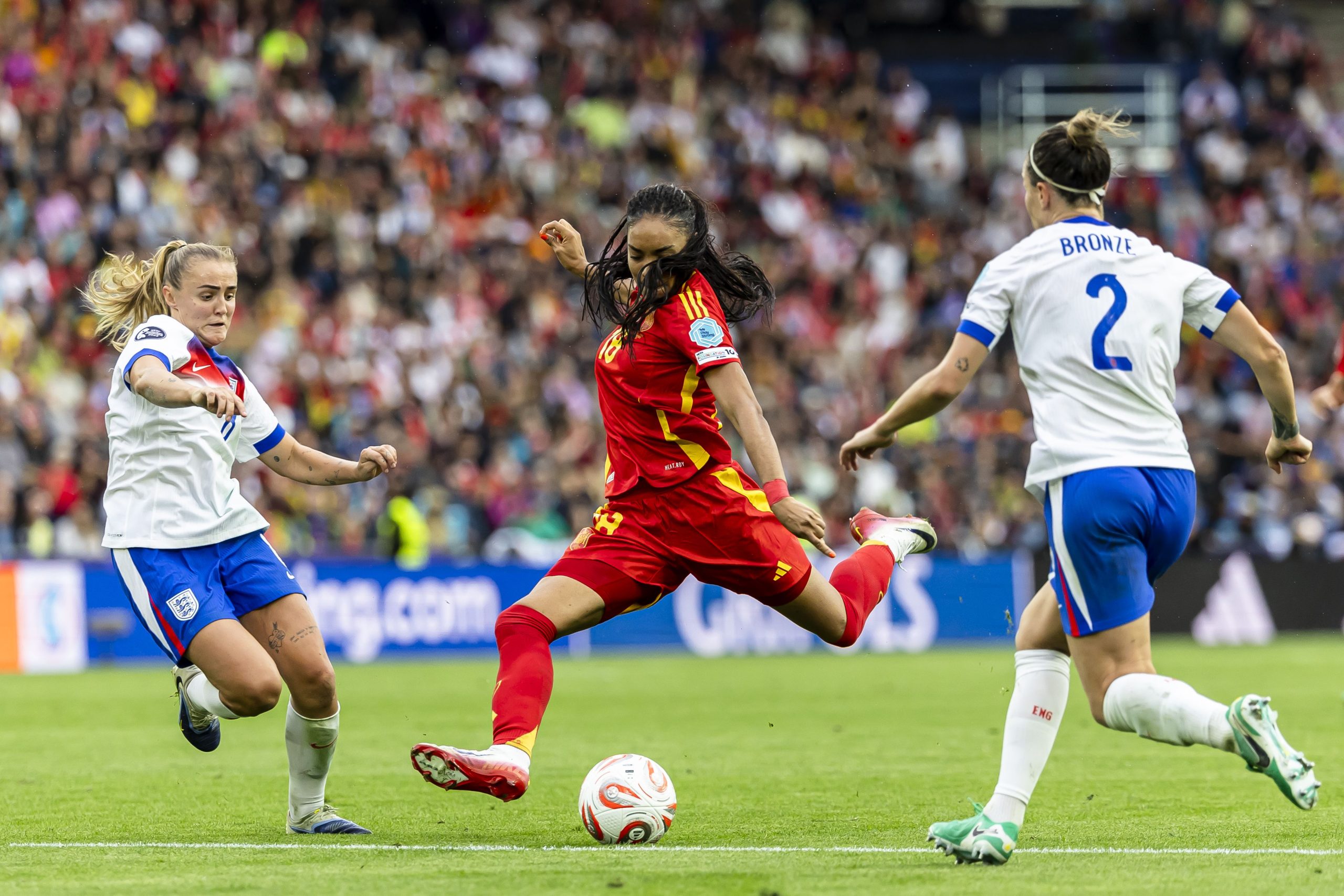 A UEFA Women's EURO match continues with players wearing various ID UNLIMITED badges
